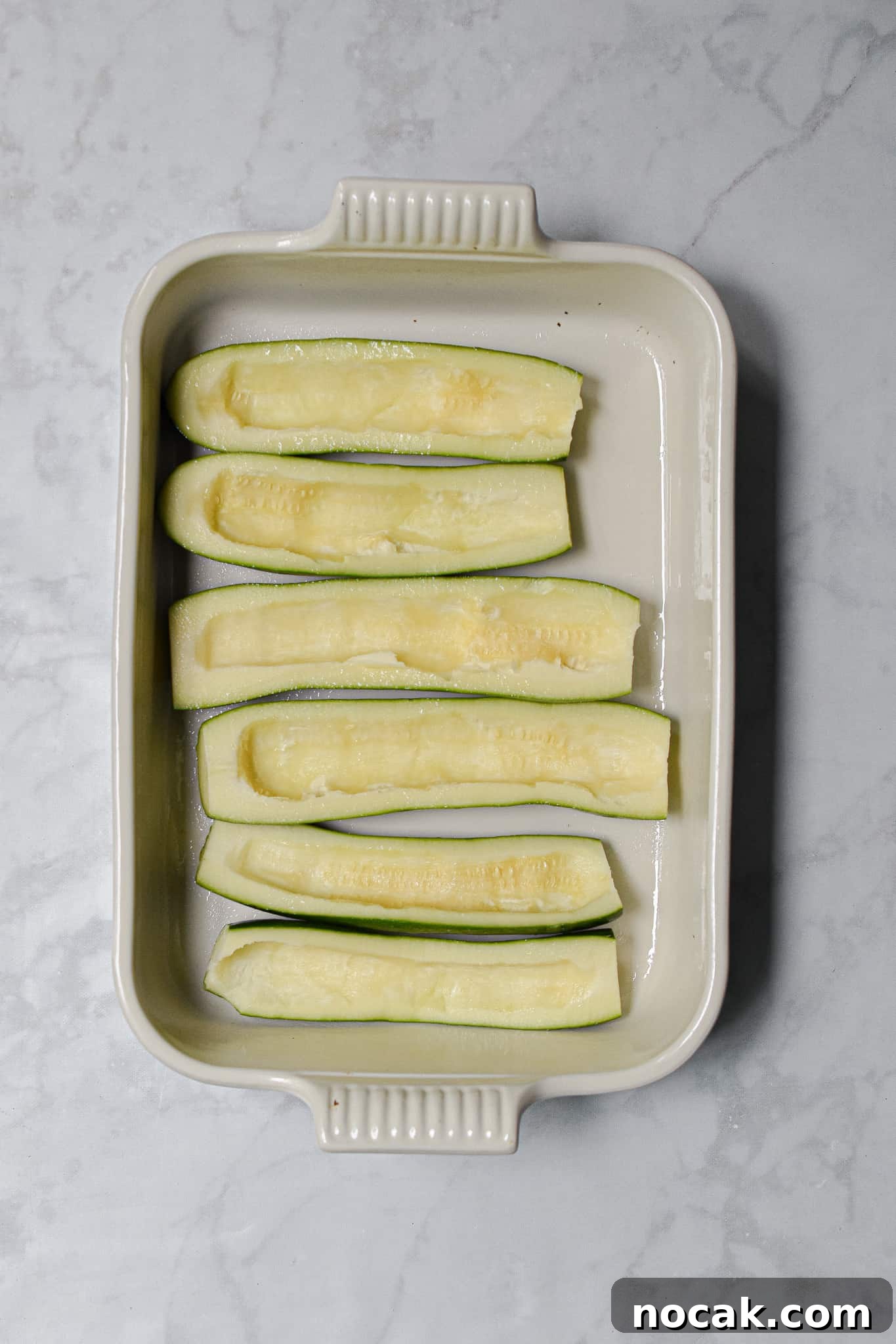 Buffalo Chicken Stuffed Zucchini Boats with Cheesy Filling 4 The zucchini are hollowed out and put in a baking dish