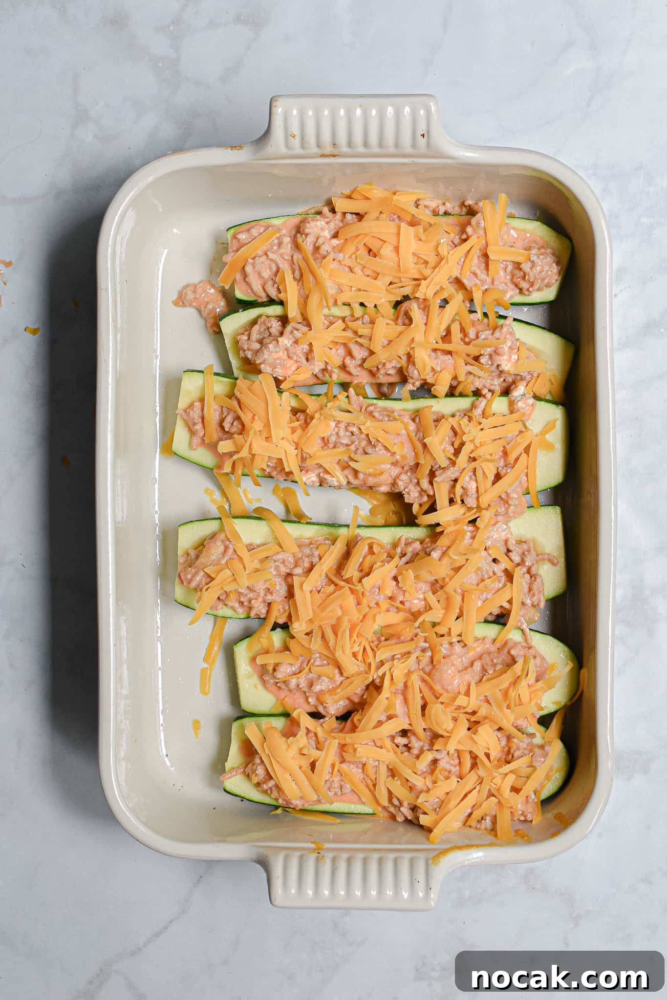 Buffalo Chicken Stuffed Zucchini Boats with Cheesy Filling 8 The buffalo chicken stuffed zucchini are topped with shredded cheddar