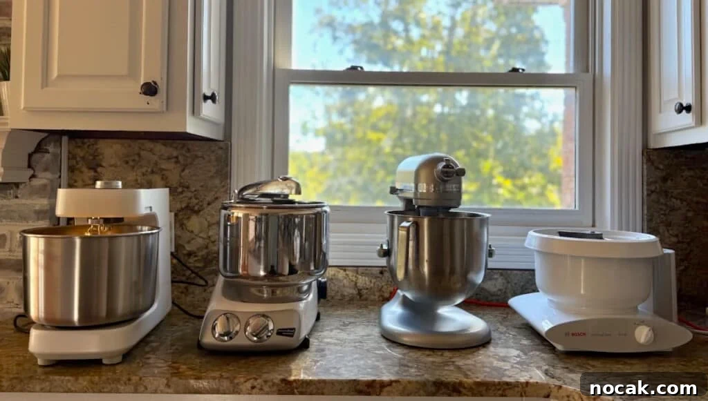 Stand Mixer Reviews: KitchenAid, Bosch, Ankarsrum & Ooni Compared 2 Four stand mixers sitting on a countertop.