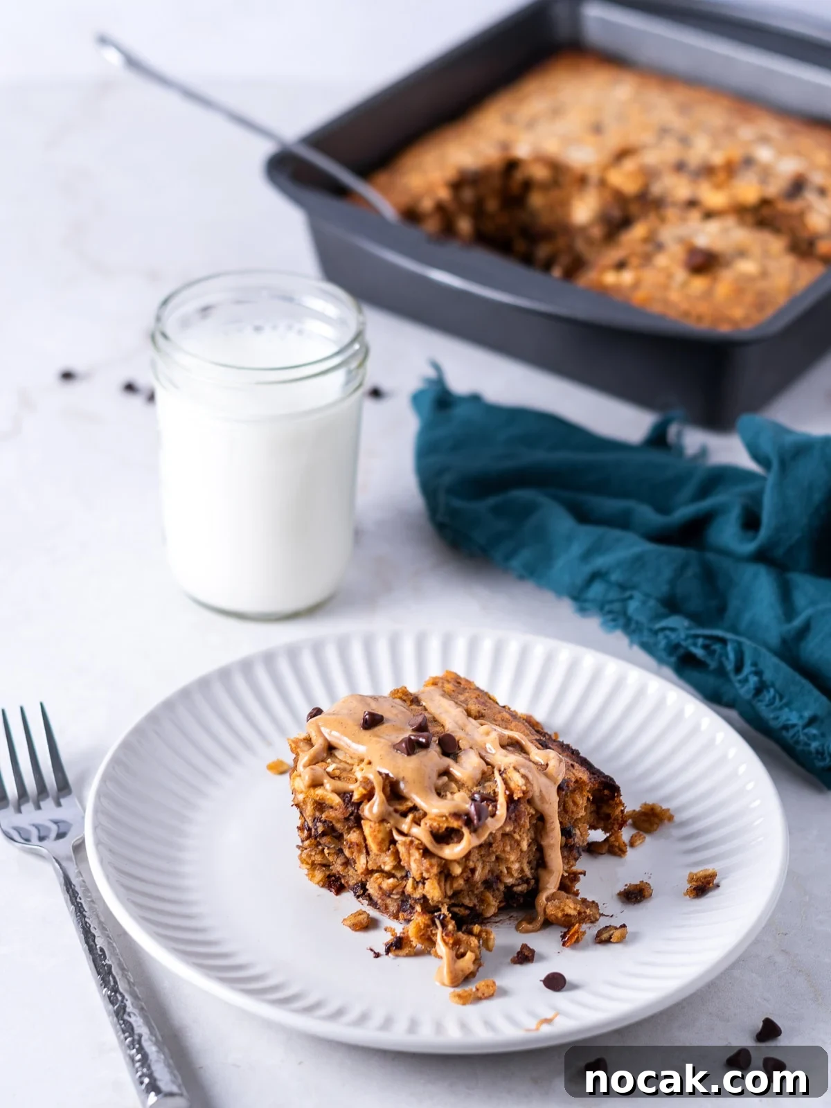 Peanut Butter Baked Oats with Maple and Banana 3 piece of baked oatmeal removed from pan and drizzled with peanut butter