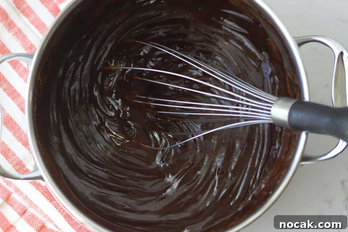 Hot Chocolate without Cocoa Powder: Simple Homemade Recipe 7 a pot of melted chocolate chips with a whisk in it