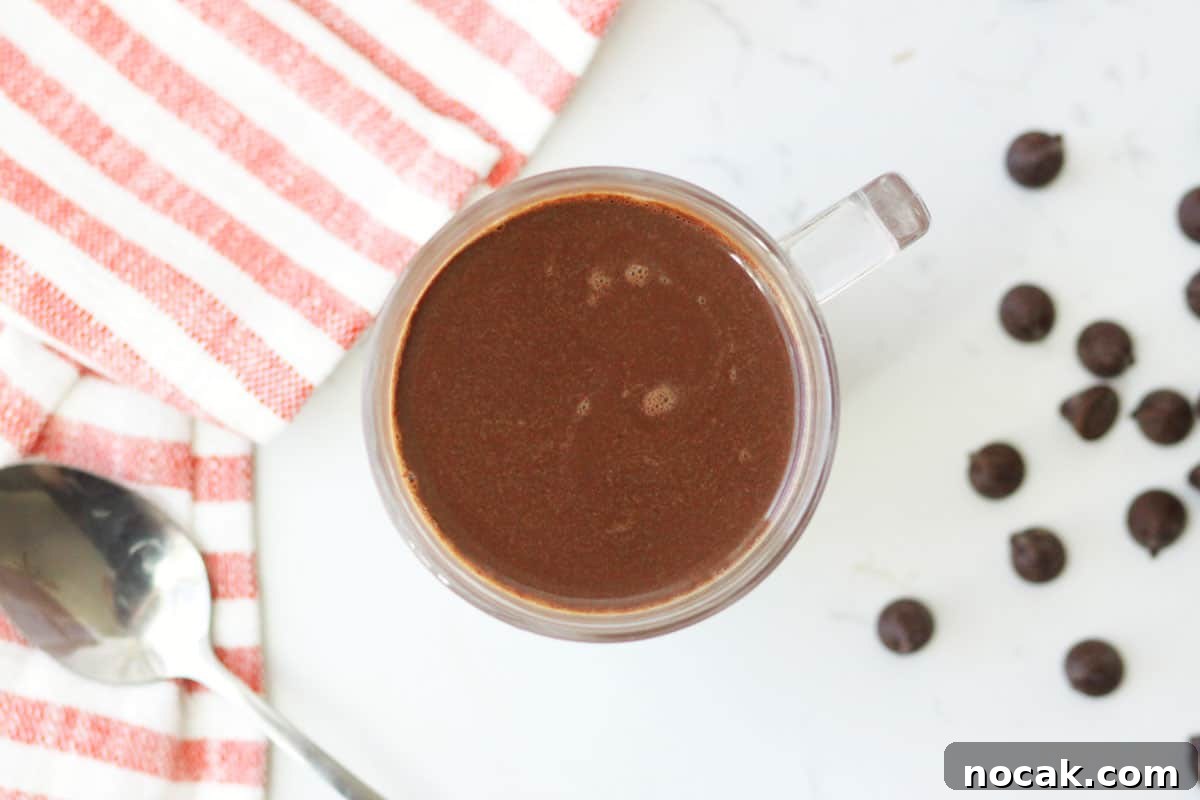 Hot Chocolate without Cocoa Powder: Simple Homemade Recipe 9 a cup of creamy hot chocolate with a red and white striped towel behind it