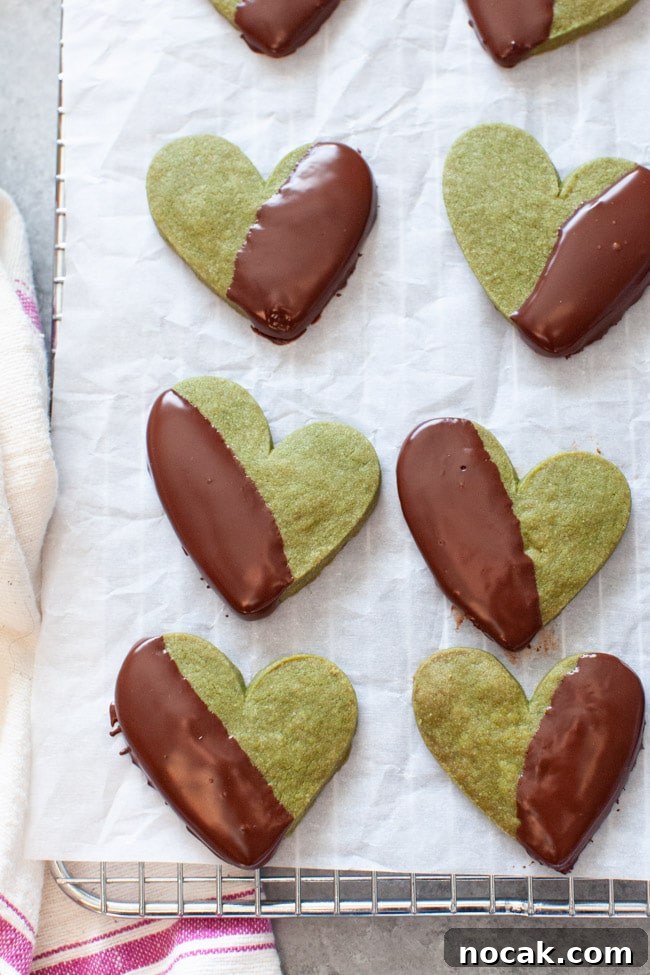 Matcha Cookies Heart Shaped Matcha Cookies Dipped in Chocolate on White Parchment Paper