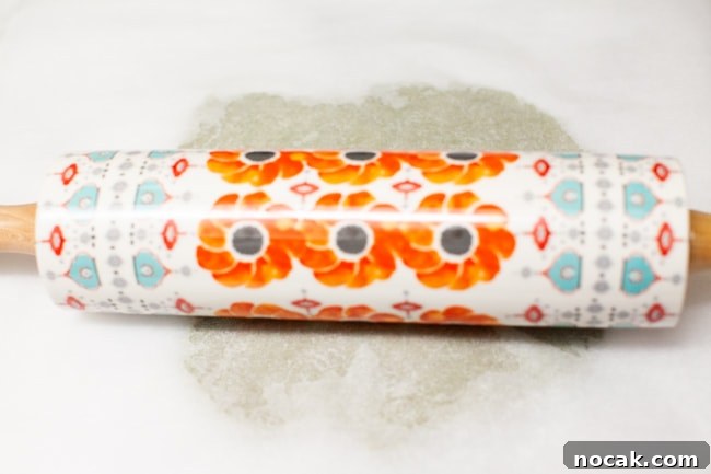 Rolling dough Cookie dough rolled under parchment paper