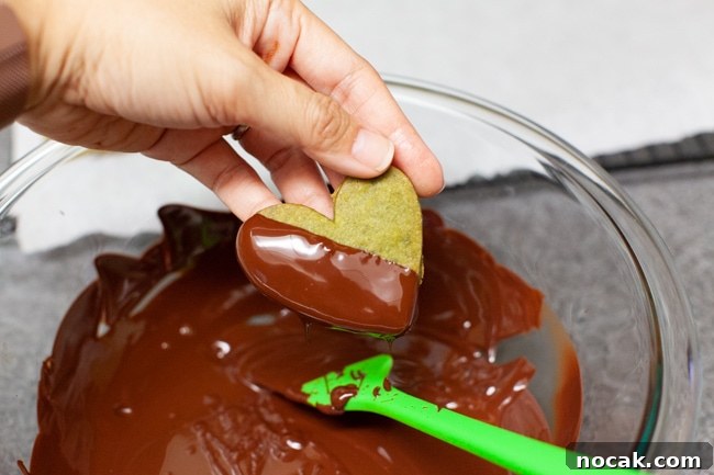 Dipping cookies Dipping heart-shaped cookies into melted chocolate