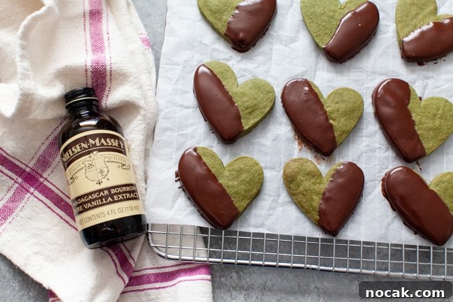Finished cookies Chocolate Dipped Heart Shaped Matcha Cookies on parchment paper