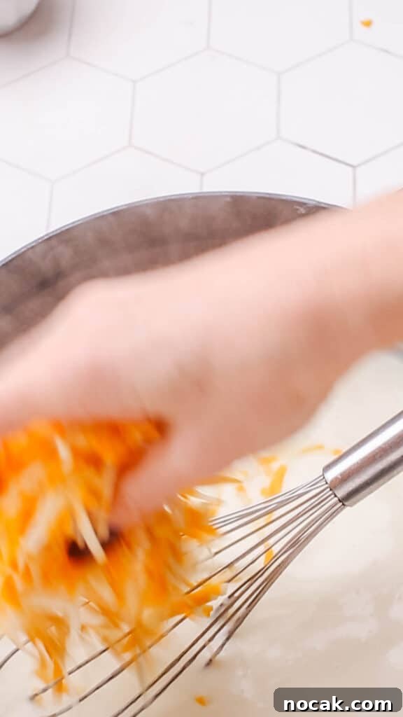 Creamy Cheese Sauce Recipe for Mac and Cheese 8 Adding cheddar cheese to sauce for macaroni and cheese.