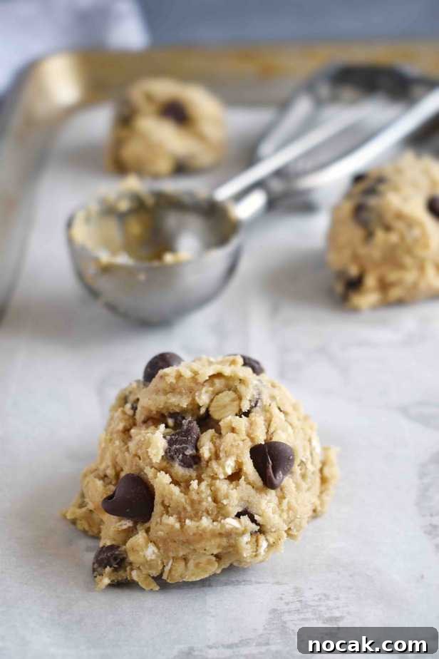 Chewy Oatmeal Chocolate Chip Cookie Recipe for Perfect Texture 6 cookie dough ball with cookie scoop in background