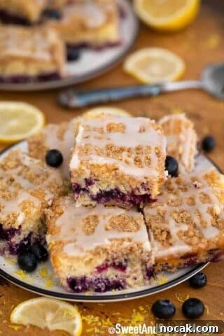 Blueberry buckle bars with fresh blueberries on a plate.