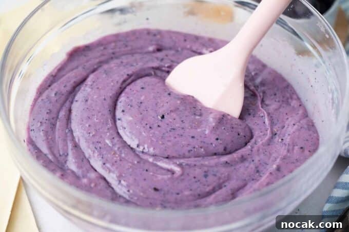 Creamy No-Bake Blueberry Fudge Recipe 7 Stirring blueberry fudge in a bowl.