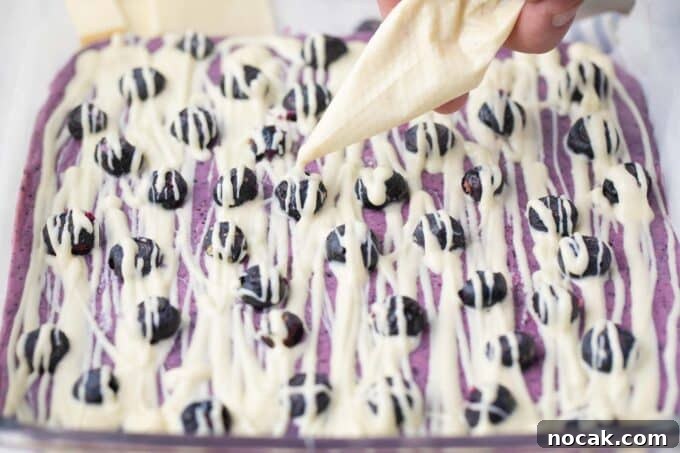 Creamy No-Bake Blueberry Fudge Recipe 8 Drizzling white chocolate on top of blueberry fudge.