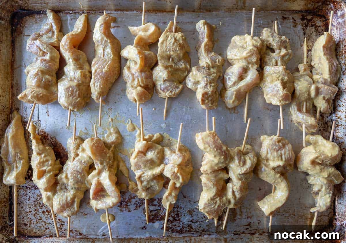 Chicken Satay Skewers with Creamy Peanut Dipping Sauce 5 Skewered chicken strips ready for the grill for satay skewers.