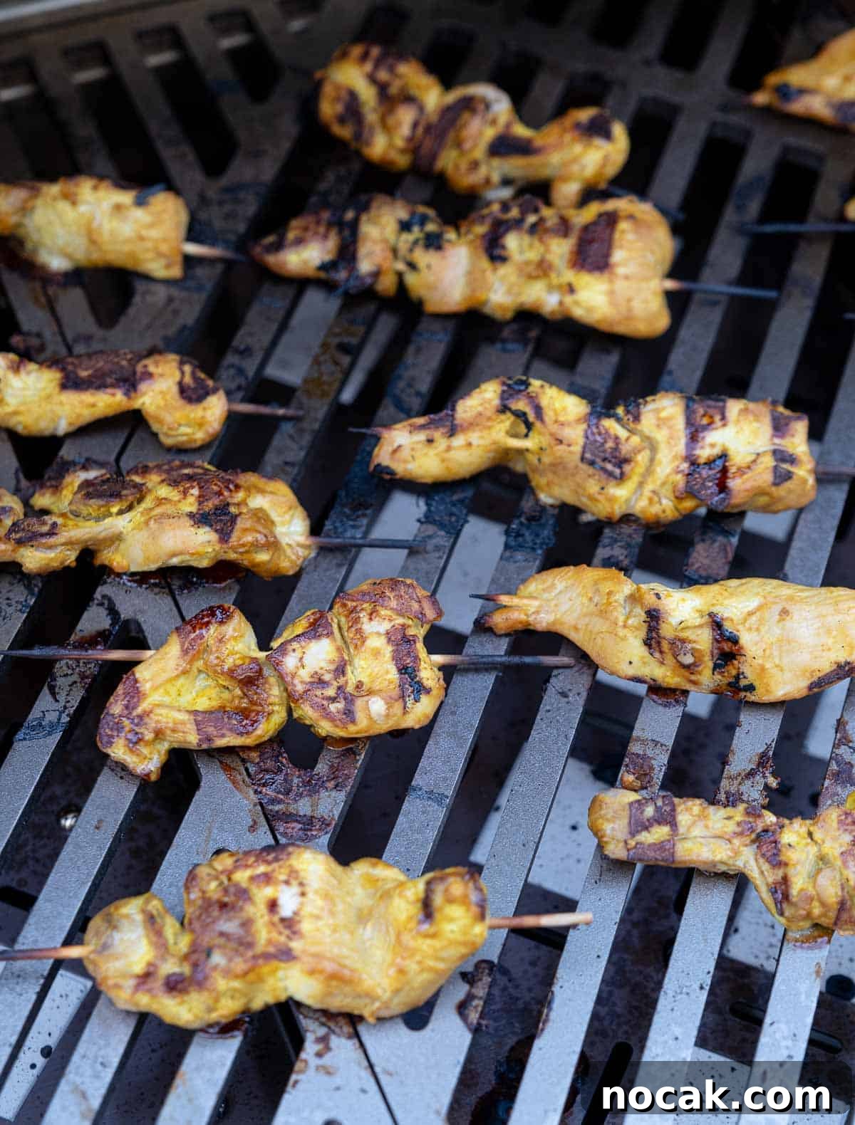 Chicken Satay Skewers with Creamy Peanut Dipping Sauce 6 Chicken skewers on a gas grill grate over direct heat.