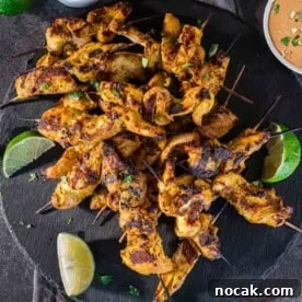 Chicken Satay Skewers with Creamy Peanut Dipping Sauce 9 Grilled chicken satay skewers on a slate plate with peanut dipping sauce.