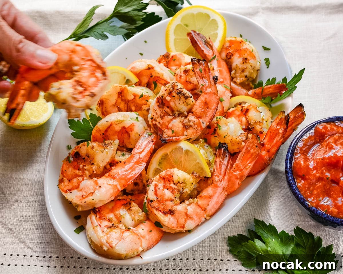 Citrus-Grilled Shrimp Cocktail with Zesty Dipping Sauce 9 Grabbing a grilled shrimp cocktail from the platter.