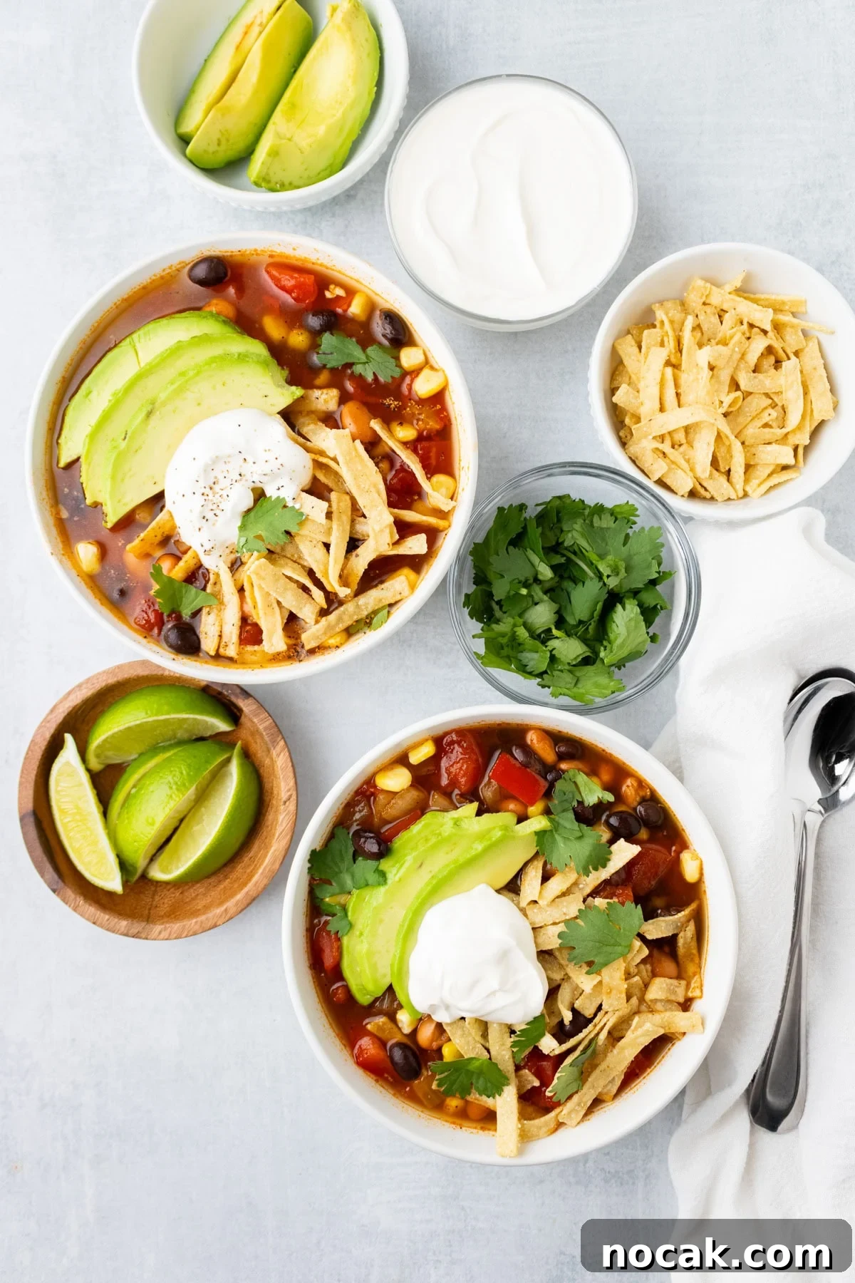 An overhead image of two bowls with garnishes and toppings on the side.