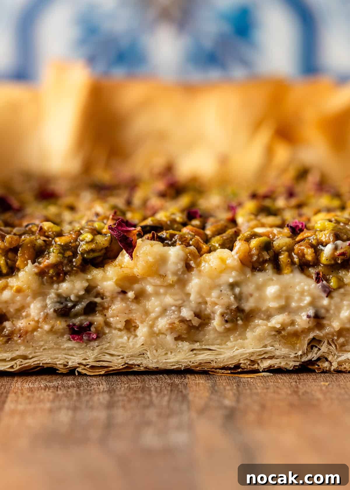 Baklava Cheesecake Bars with Honeyed Pistachios 14 closeup side view: showing all the layers of Baklava Cheesecake