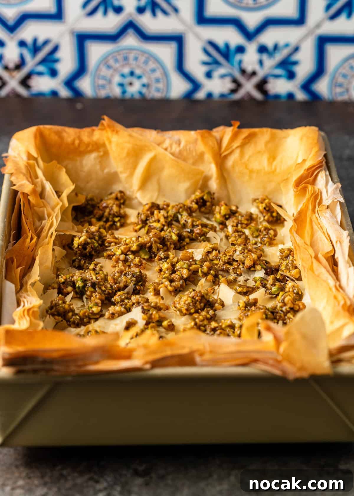 Baklava Cheesecake Bars with Honeyed Pistachios 10 overhead process shot: baked baklava cheesecake in pan