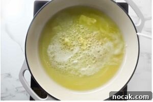 Creamy Chicken Alfredo Tortellini Recipe for Quick Weeknight Dinner 8 Overhead view of white pot on stove with browning melted butter.
