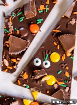 pieces Halloween candy bark topped with sprinkles, candy eyes, Reese's and Kit Kats