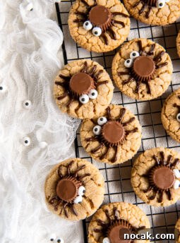 peanut butter spider cookies on cooling rack next to white cloth.