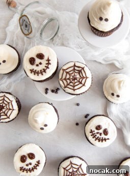 tops of chocolate cupcakes with vanilla frosting decorated as skeletons, spider webs and ghosts.