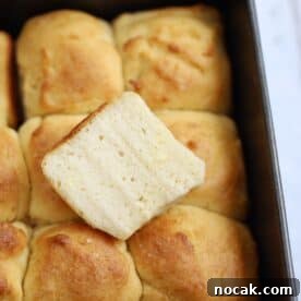 Gluten-Free Hawaiian Rolls Recipe: Soft, Sweet, and Vegan Option 19 A tray of gluten free Hawaiian rolls with one cut in half on top.