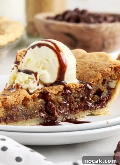 A slice of Chocolate Chip Pie, with ice cream and drizzled chocolate on top.