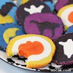 Spiderweb Red Velvet Cake with Chocolate Cream-Cheese Frosting 3 Plate of baked Slice and Bake Halloween Cookies with a bite taken out of the front cookie.