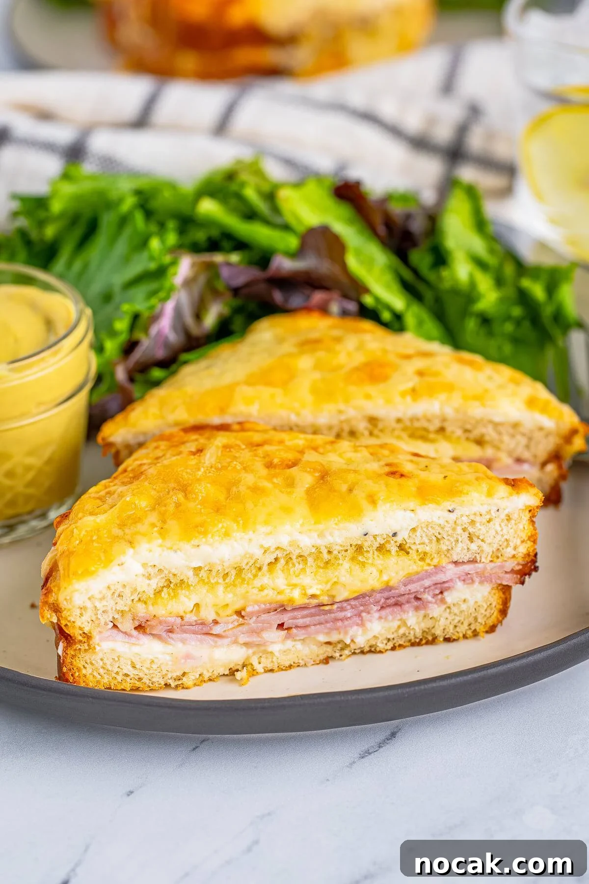 One Croque Monsieur Recipe on plate cut in half with salad.