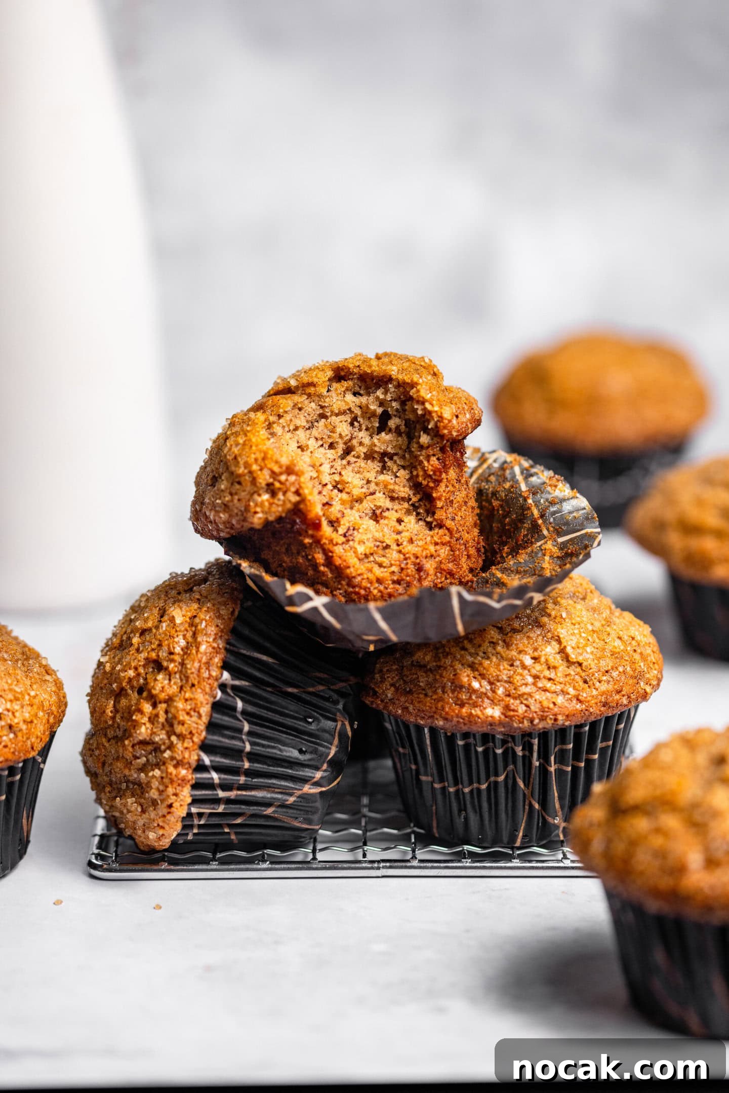 A stack of banana muffins with a bite missing from the top one.