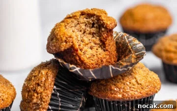 A stack of banana muffins with a bite missing from the top one.