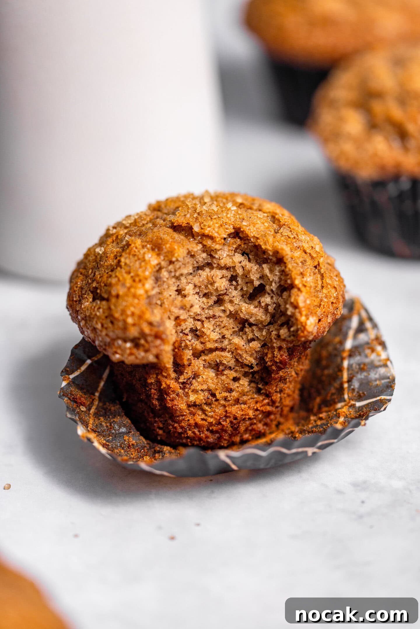 Close up of banana muffin with a bite missing showing moist and tender crumb interior