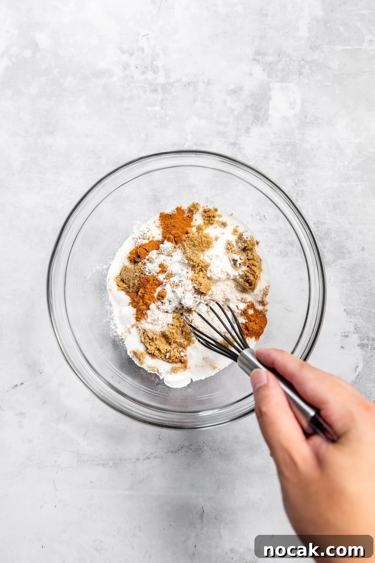 Dry ingredients being whisked together in a mixing bowl