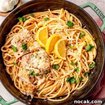 Lemon chicken pasta, garnished with grated parmesan and lemon slices.