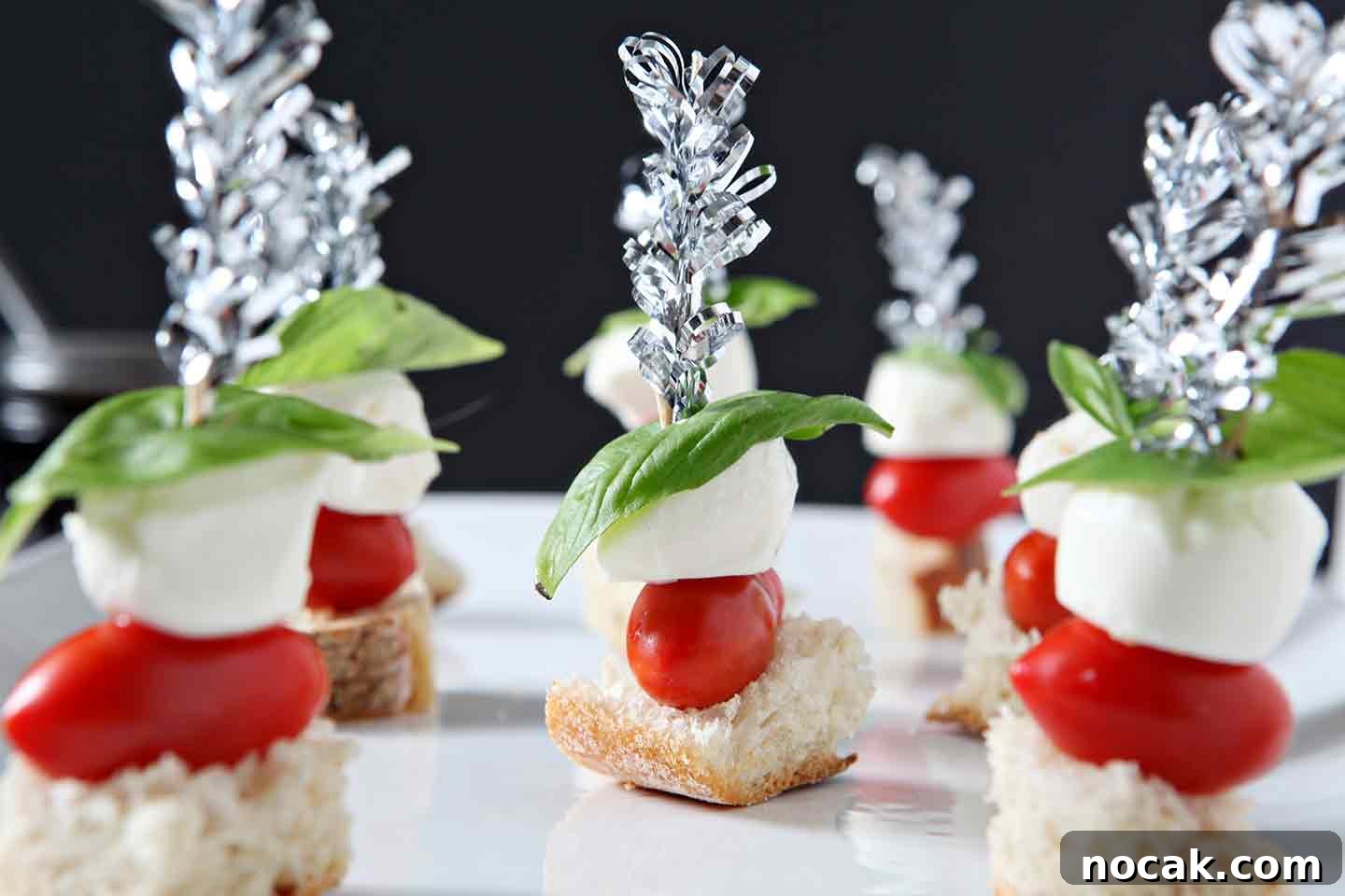Caprese Skewers Recipe: Fresh Tomato, Mozzarella & Basil Bites 3 close up of caprese skewers on a white plate