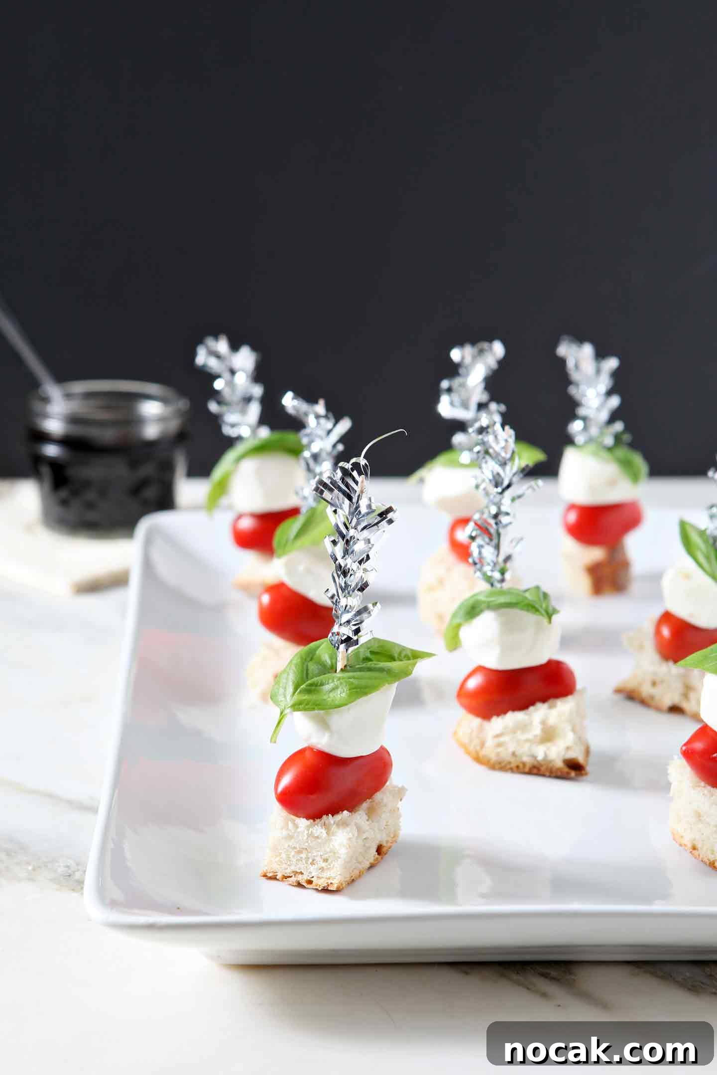 Caprese Skewers Recipe: Fresh Tomato, Mozzarella & Basil Bites 5 caprese skewers on a white plate
