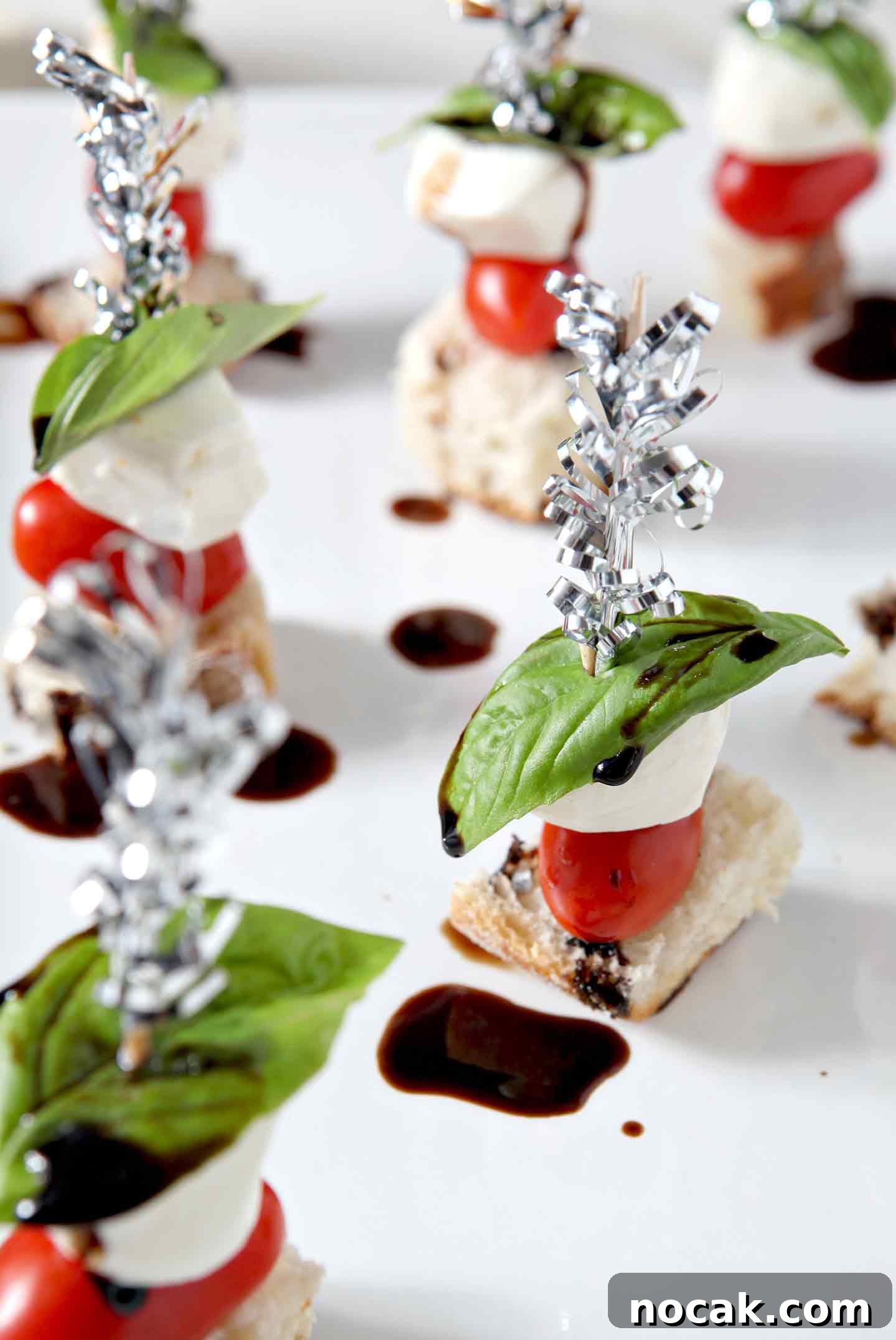 Caprese Skewers Recipe: Fresh Tomato, Mozzarella & Basil Bites 6 caprese skewers on a white plate with balsamic
