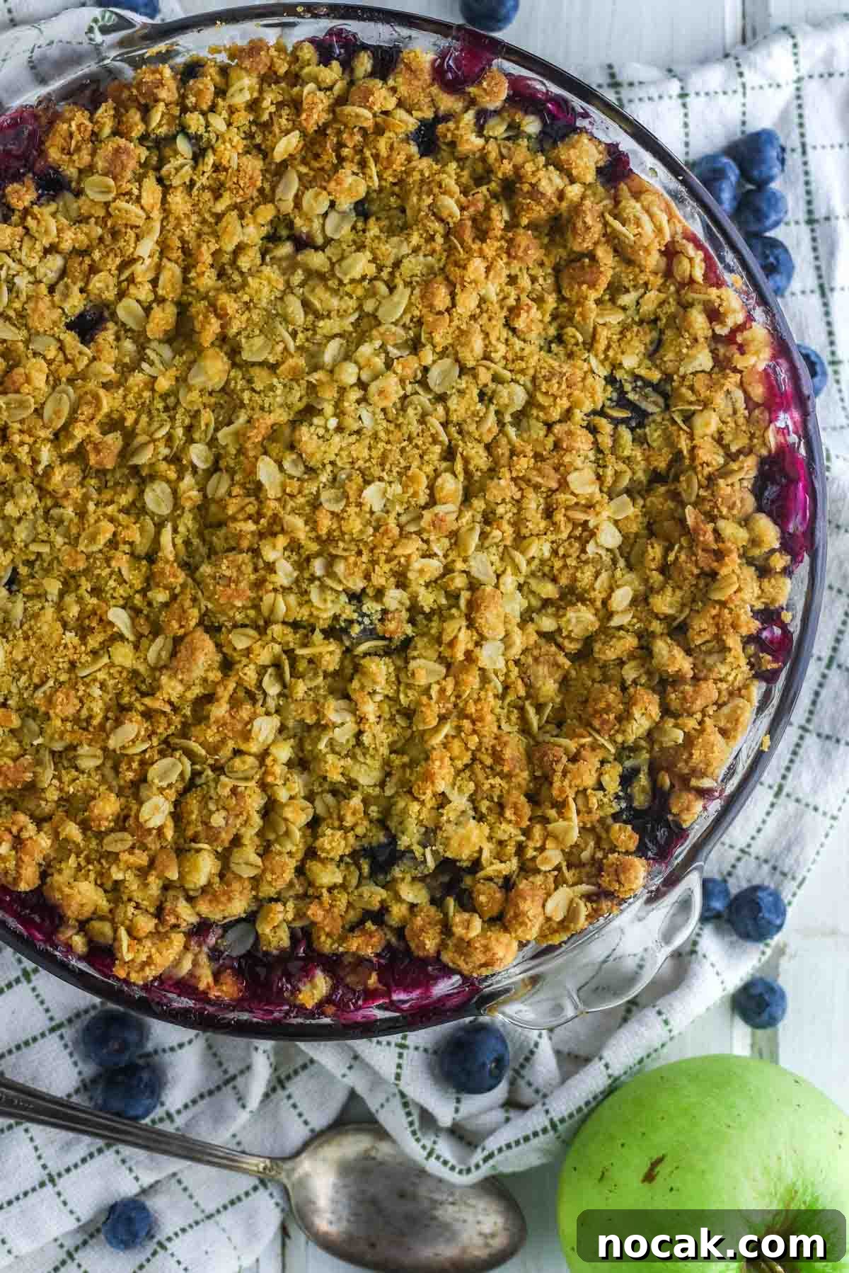 overhead shot of glass pie dish filled with apples and blueberries and a crumble topping