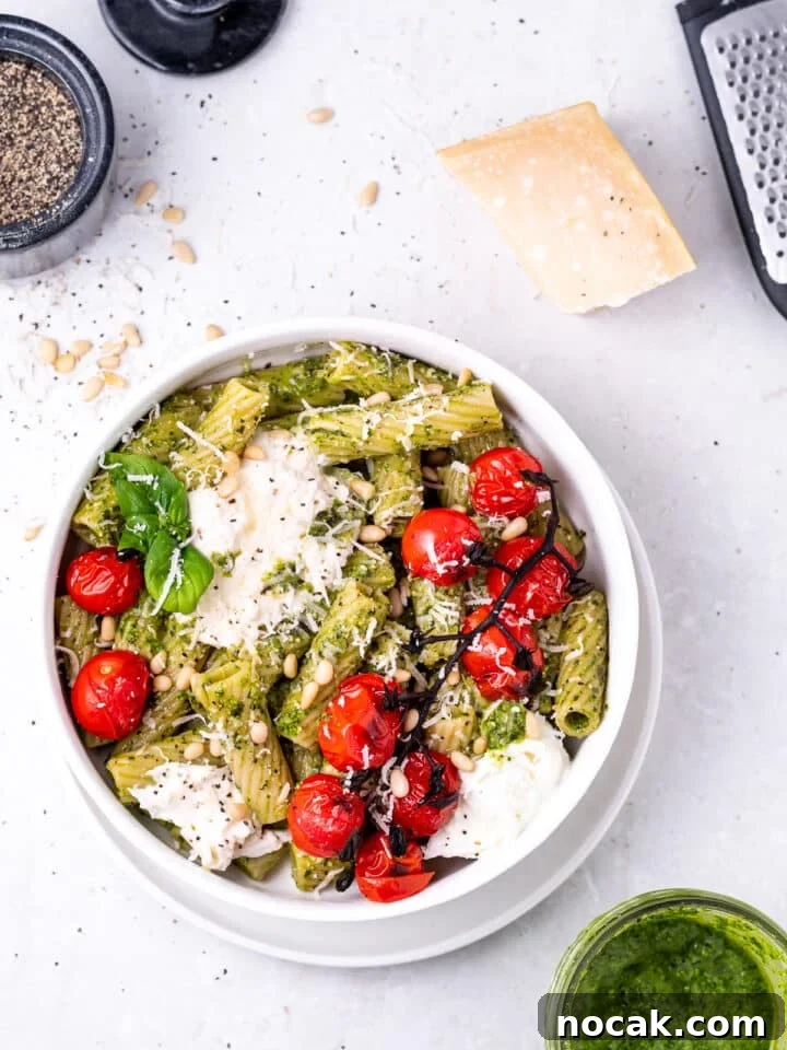 Pesto Rigatoni with Burst Cherry Tomatoes and Creamy Burrata 11 white bowl with the featured recipe, a block of parmesan cheese and microplane grater