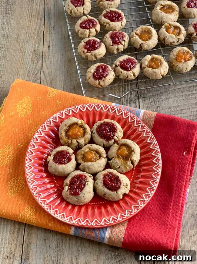 Jam Thumbprint Cookies: Baking Memories at a Cookie Party 3 Jam thumbprints on red plate with more on cooling rack in background.