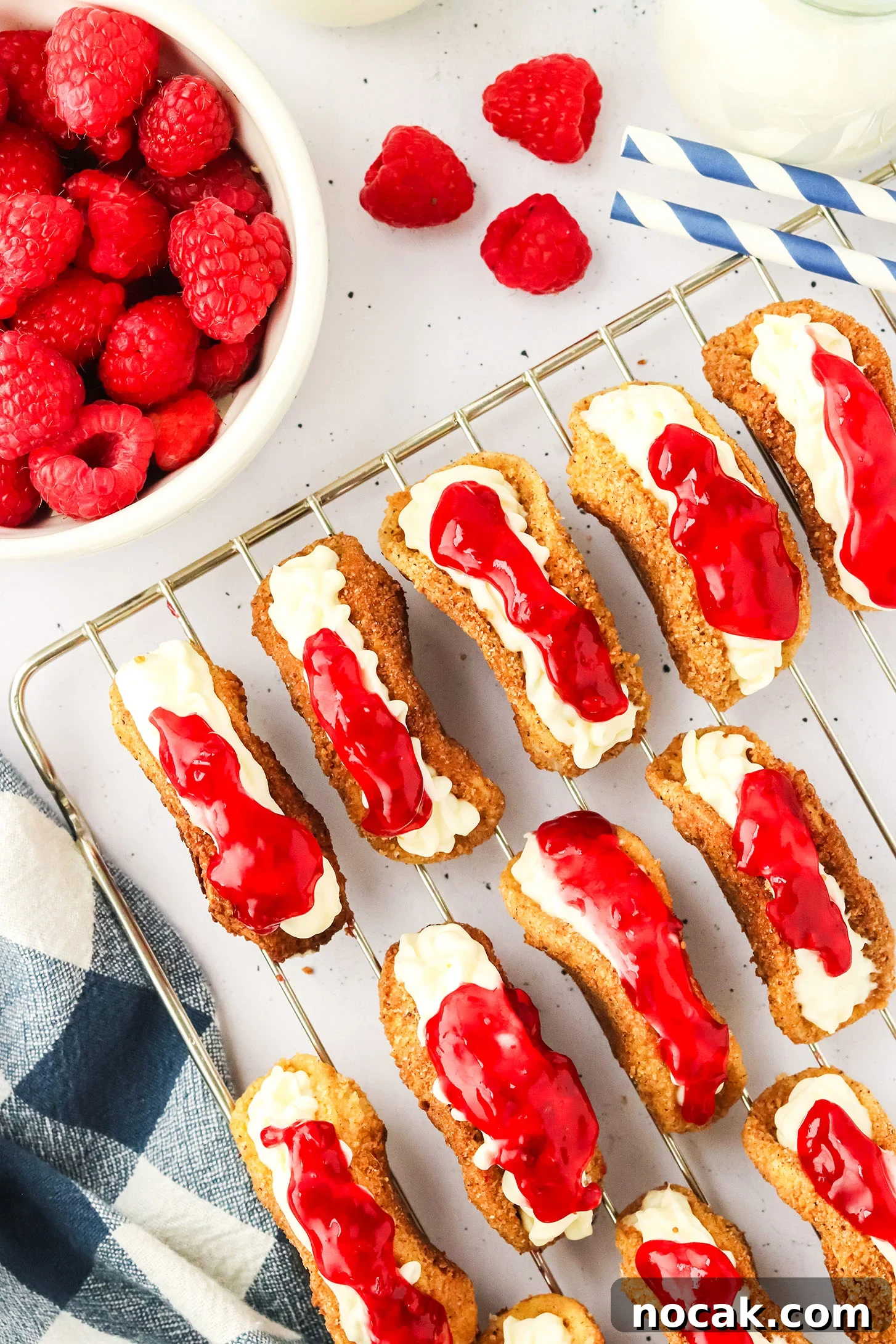 Raspberry Cheesecake Tacos: Creamy Dessert Taco Recipe 10 wire cooling rack topped with multiple raspberry cheesecake mini tacos