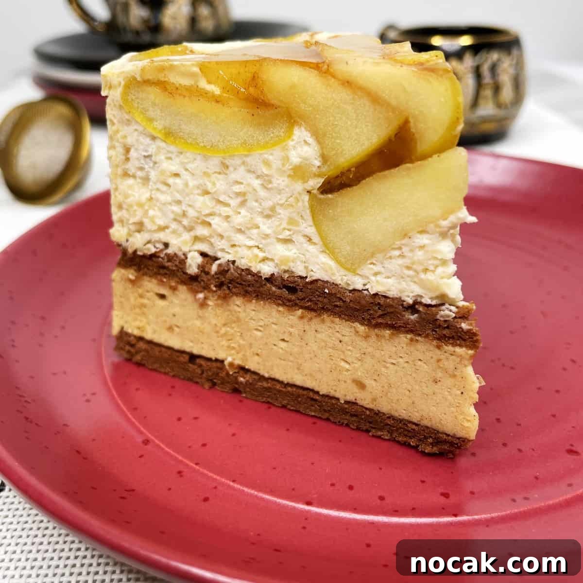 Apple Mousse Cake — Pomme d'Ève Recipe for Light Apple Dessert 2 A single slice of apple mousse cake on a red dessert plate with a tea set