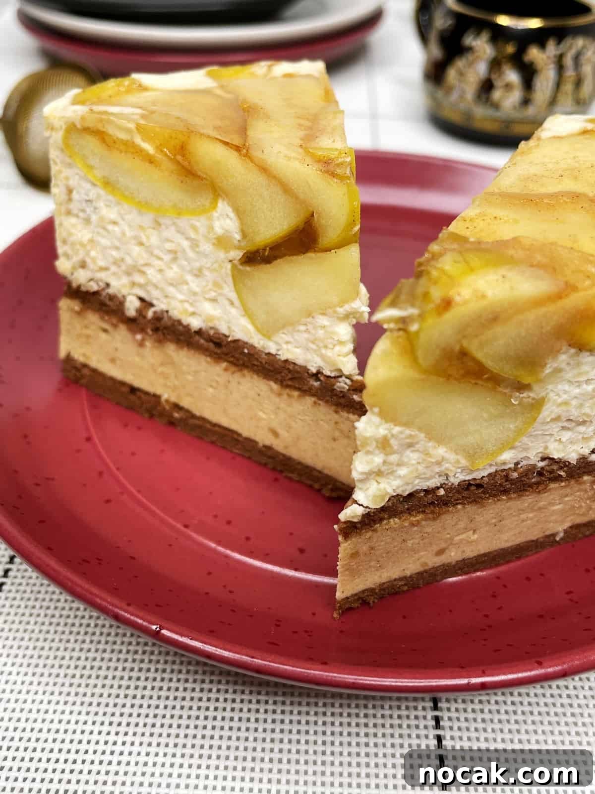 Apple Mousse Cake — Pomme d'Ève Recipe for Light Apple Dessert 4 Two slices of apple mousse cake on a red dessert plate with teacups and saucers