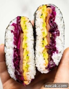sushi sandwich close up overhead shot of hand holding Onigitazu showing filling