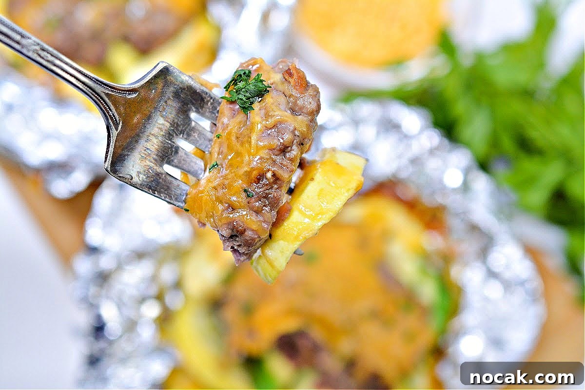 Keto Cheeseburger Foil Packets for Air Fryer Cooking 7 A fork with a bite of keto cheeseburger and yellow squash