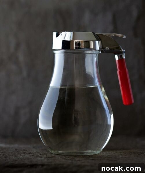 A syrup canister half-filled with simple syrup.