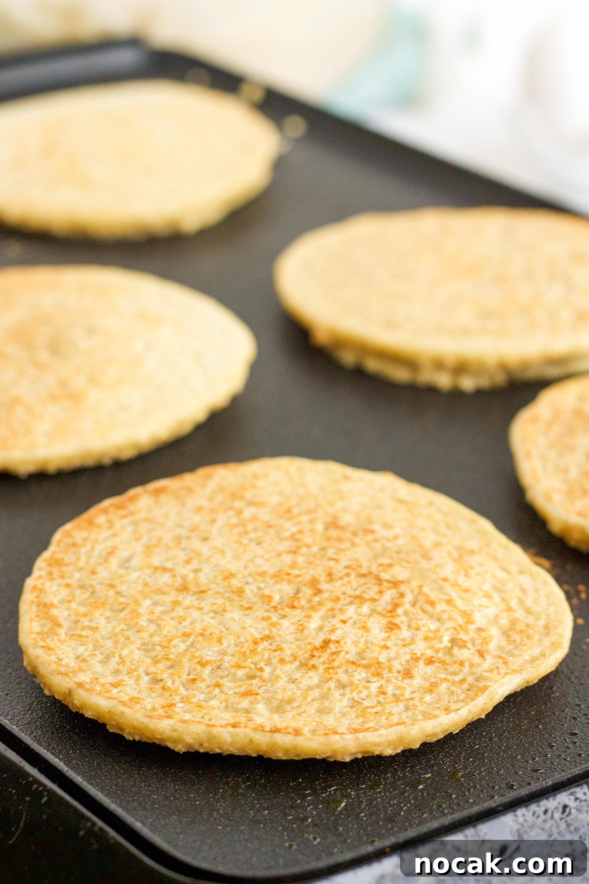Fluffy Oat Flour Pancakes Recipe for Light, Tender Stacks 7 Flipped over oat flour pancakes on the griddle.