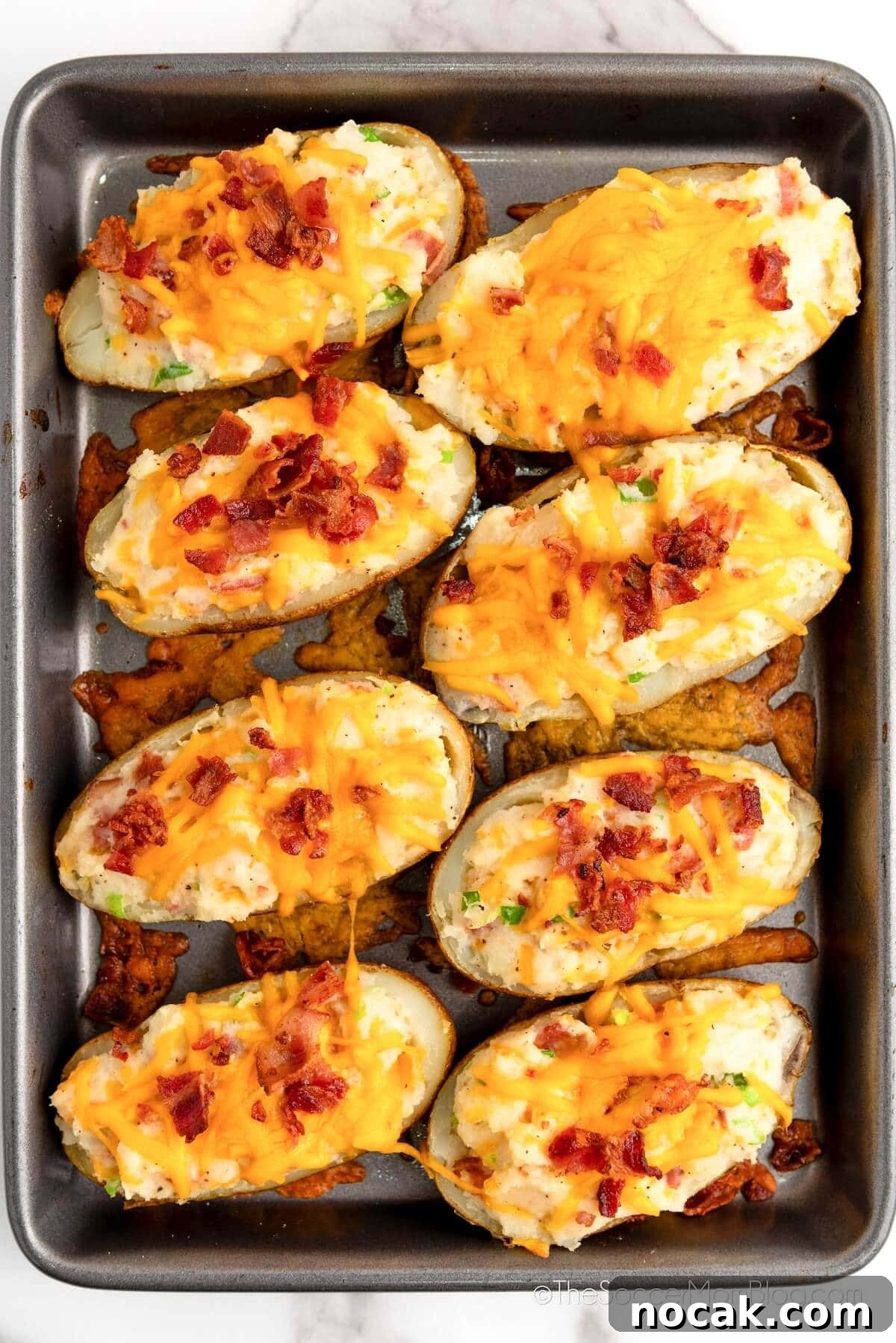 Ultimate Twice-Baked Potatoes Recipe for Crispy, Creamy Filling 6 Twice Baked Potatoes in a baking pan.