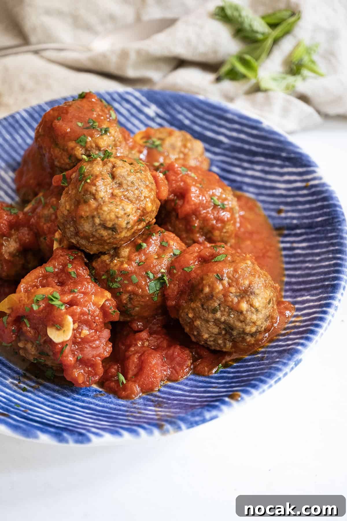 Classic Italian Fried Meatballs Recipe — Crispy, Savory Plates 2 Meatballs covered in tomato sauce in a bowl.
